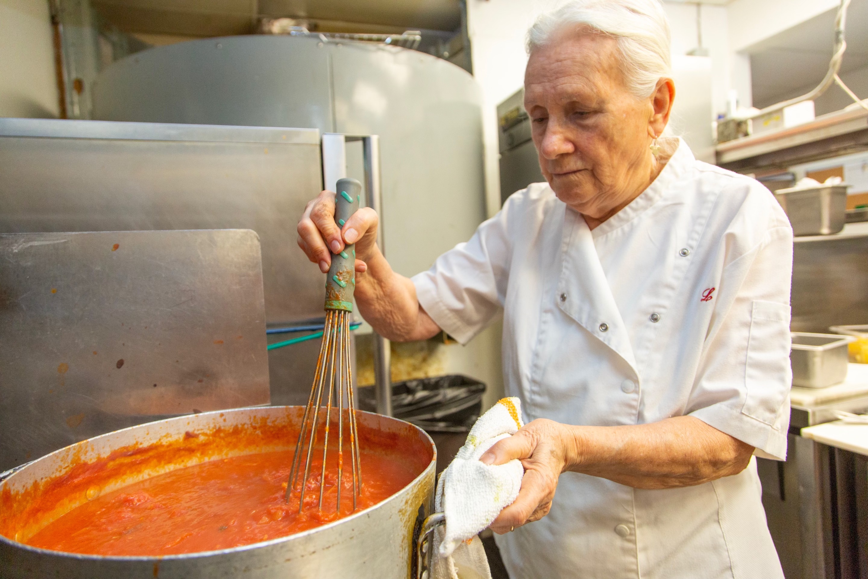 Molto's chef stirring a pot of tomato sauce